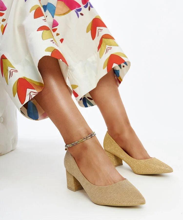 Złote świecące czółenka na słupku Laity