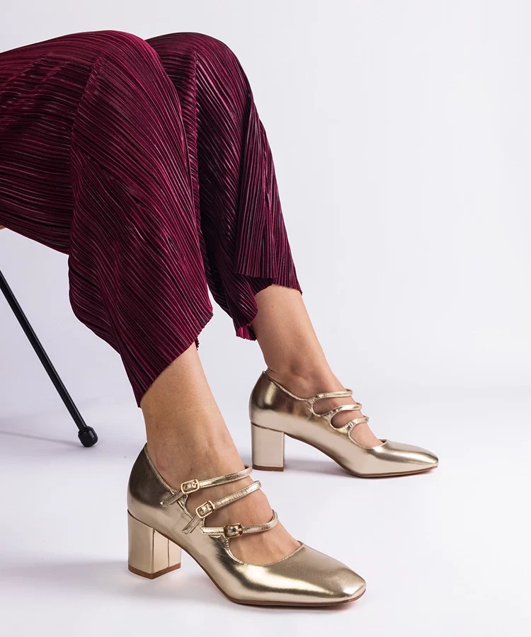 Złote czółenka na słupku z ozdobnymi sprzączkami Izida